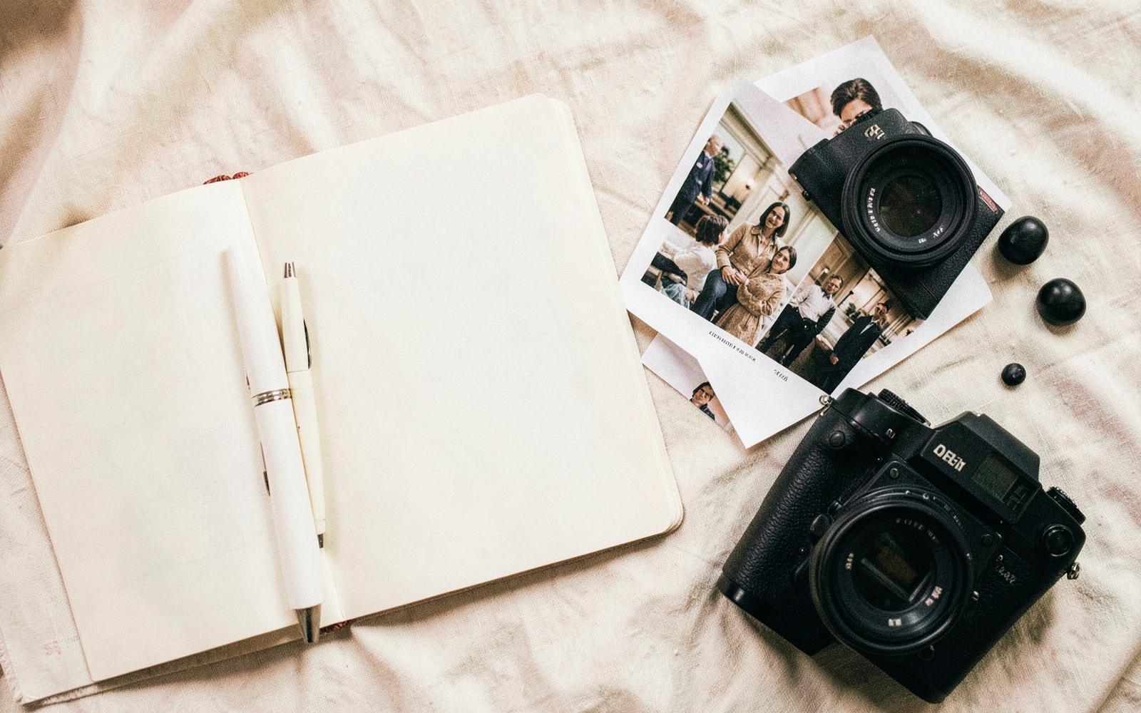Carnet de notes, tirages photo et appareil sur un bureau